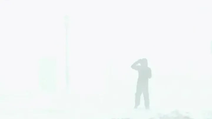 A news anchor disappearing into the snow in a white-out storm, a not at all dramatic metaphor.