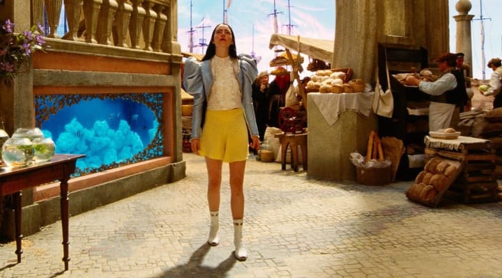 Emma Stone wanders a "city" with aquariums in the building walls and a Trapper Keeper nebula galaxy sky.